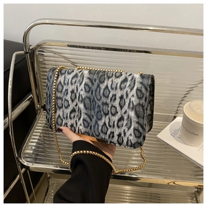 Detalle del bolso con estampado de leopardo, cadena dorada y acabado de borde metálico