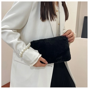 Detail van zwarte faux fur handtas met elegant parelhandvat voor de herfst en winter