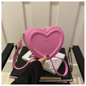 Detail of pink heart-shaped bag with gold hardware and FASHION & BAG lettering