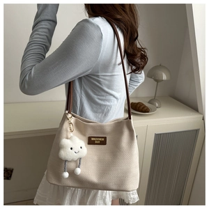 Détail du sac cabas crème texturé gaufré avec bandoulière en cuir et charm nuage