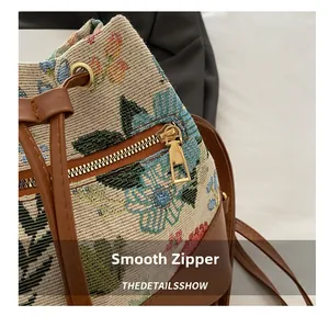 Detailed macro view of the smooth golden metal zipper and ethnic floral woven fabric texture