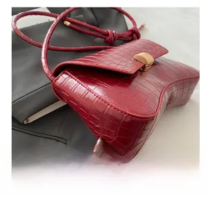 Vue détaillée du sac sablier rouge à texture crocodile avec boucle en métal doré
