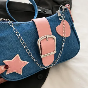 Λεπτομέρεια μπλε τσάντας denim με ροζ αστέρια και μεγάλη ασημένια μεταλλική αγκράφα
