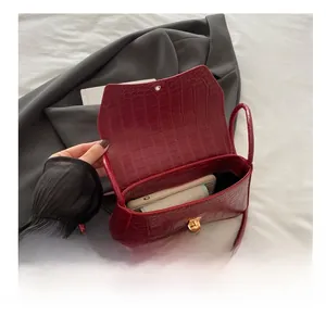Vue intérieure du sac bandoulière bordeaux motif crocodile montrant la capacité de rangement