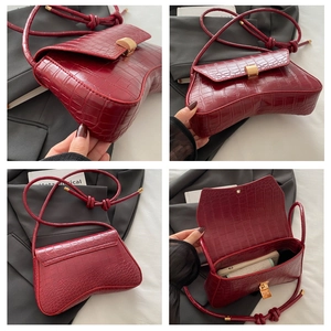 Détails du sac à main bordeaux gaufré crocodile avec fermoir rotatif en métal doré chic