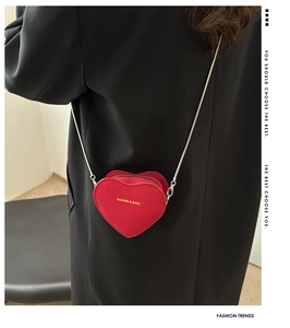 Détail du mini sac à bandoulière rouge en forme de cœur avec chaîne dorée en cuir PU