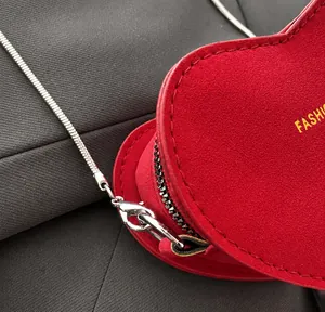 Détail macro du crochet argenté et de la fermeture éclair du sac cœur rouge