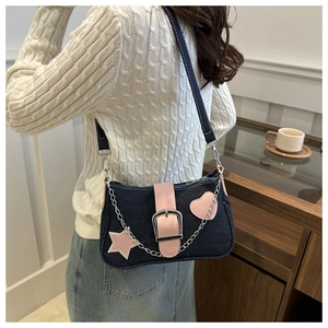 Detalle de bolso de mezclilla Y2K con parches de corazón rosa y cadena de plata