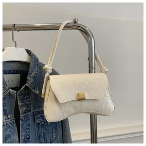 Détail du sac bandoulière blanc à motif crocodile avec boucle dorée et bandoulière nouée