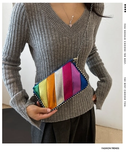 Detail of rainbow metallic crossbody bag with silver rivet trim and fine chain strap