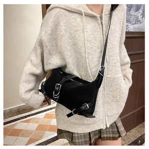Dettaglio borsa a tracolla nera stile utility con fibbie argentate e materiale in nylon