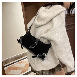 Dettaglio borsa a spalla in pelle scamosciata nera con fibbie d'argento su modella