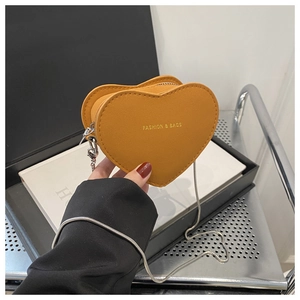 Détail du mini sac à main jaune en forme de cœur avec lettrage doré et chaîne argentée