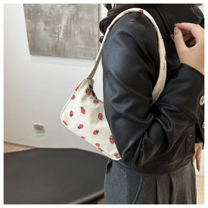 Borsa sottobraccio in velluto a coste bianco con stampa fragola indossata da modella