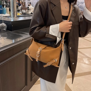 Borsa a tracolla retrò caramello con fibbie argentate in un ambiente urbano chic