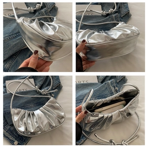 Detailed views of silver pleated crescent bag with magnetic buckle and inner lining