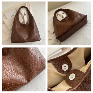 Détail d'un sac porté épaule tissé marron foncé avec fermoir magnétique et doublure
