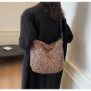 Detailweergave van grote tas met luipaardprint gedragen op de schouder door een model