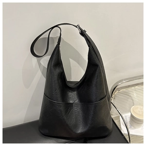 Détail du sac cabas en cuir noir avec large bandoulière et boucle en métal argenté