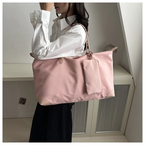 Detail einer großen rosa Tragetasche mit kleiner Seitentasche und verstärkten Leder-Bodenecken