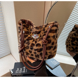 Dettaglio borsa peluche leopardata con pelliccia sintetica e tracolla con nodo marrone