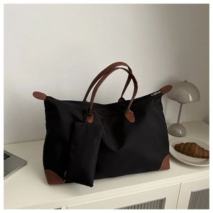 Details der schwarzen Nylon-Tasche mit braunen Ledergriffen und passender Mini-Tasche