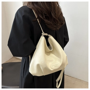 Detail of cream leather tote bag showing ZSKE & NAG FASHION logo and soft texture