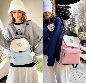 Detalle de mochilas de nailon resistente al agua en azul y rosa con lindos colgantes