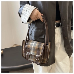 Dettaglio borsa in lana a quadri stile inglese con cinturini in pelle e fibbie argento