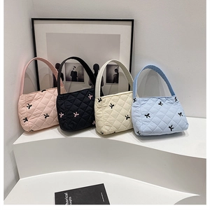 Detalle de bolsos tote de nailon acolchado con bordado de lazo en varios colores