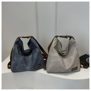 Detail of minimalist hobo bags in blue and grey with stylish wide canvas shoulder straps