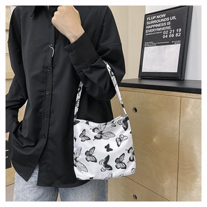 Detailaufnahme des schwarzen Schmetterlingsdrucks auf weißer Canvas-Tasche mit Trageriemen