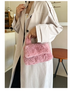Gros plan détaillé du sac en peluche rose avec chaîne en perles et fausse fourrure douce