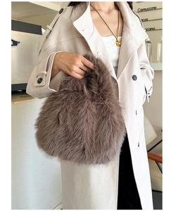 Détail de la texture d'un sac à main en fausse fourrure marron avec poignée douce