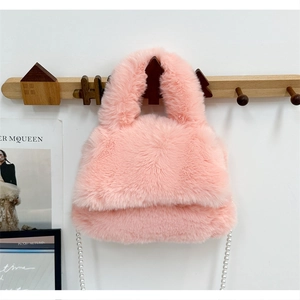 Sac à main en fausse fourrure rose avec chaîne en perles suspendu sur un crochet bois