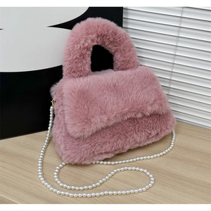 Détail du sac à main en peluche rose montrant la fourrure et la chaîne de perles