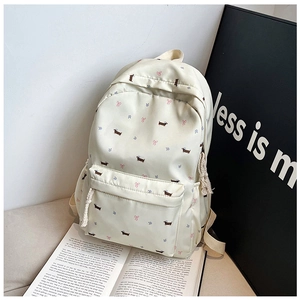 Detailweergave van de crème rugzak met teckelprint en witte touwtrekkers aan de ritsen