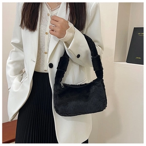 Close-up of black plush underarm bag showing soft faux fur texture and wide shoulder strap