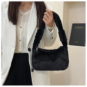 Detail of black faux fur shoulder bag with silver metal zipper and plush handle strap