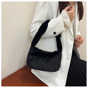 Detail of plush black faux fur shoulder bag with minimalist rectangular silhouette