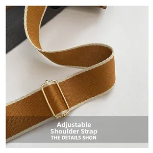 Close-up of adjustable tan fabric strap with gold metal hardware on women's handbag