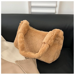 Detail view of khaki faux fur shoulder bag texture placed on a sleek black leather sofa