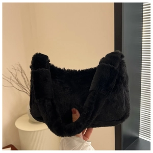 Detail of soft black plush faux fur handbag with a thick handle for winter fashion