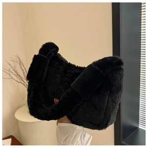 Detail view of the soft black faux fur plush texture on a crescent shoulder bag