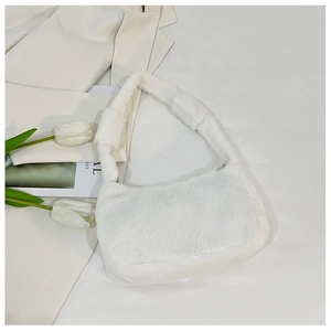 Close-up of white plush faux fur shoulder bag with soft texture and wide strap