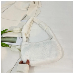 Close-up of white plush shoulder bag with faux fur texture and metal zipper detail