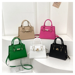 Multiple colors of structured crossbody handbags with gold metal turn locks on white display