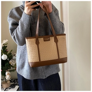 Détail du sac cabas tissé avec anses en cuir marron et décor festif de saison