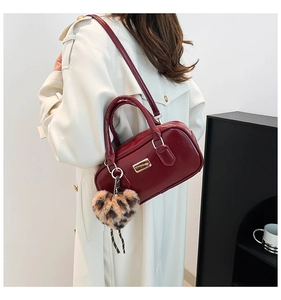 Détail du sac à bandoulière bordeaux avec un charm cœur léopard pour femme élégante