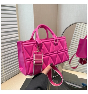 Detail of magenta quilted tote bag with geometric texture and wide woven shoulder strap